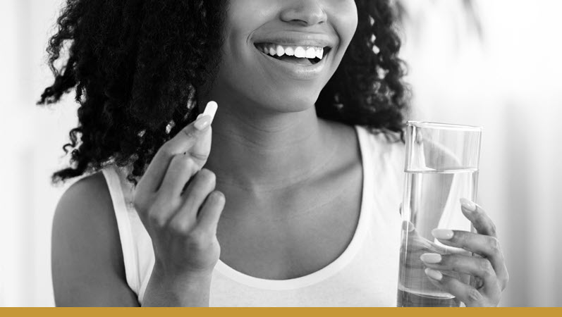 A woman taking probiotics to treat PCOS and improve gut health.